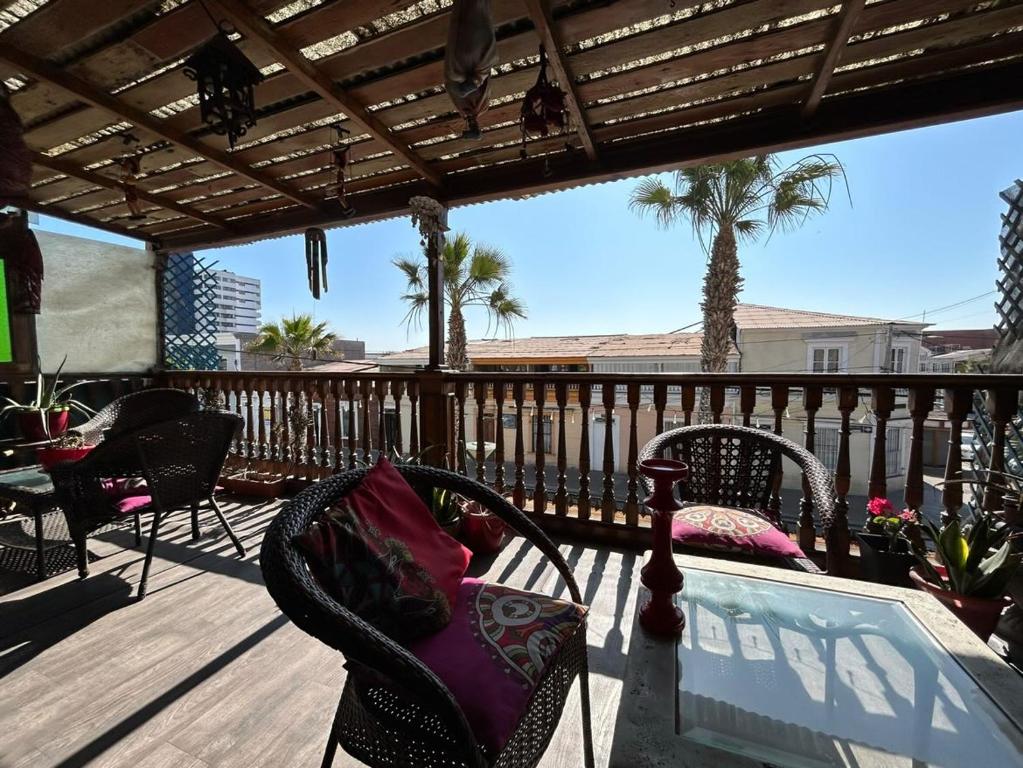 伊基克的住宿－Hostal Aloha Inn，露台配有椅子和桌子,甲板上配有桌子
