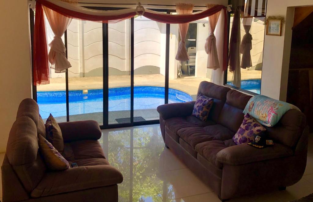 a living room with a couch and a swimming pool at Casa Playa Bahia Ballena de Osa in Uvita