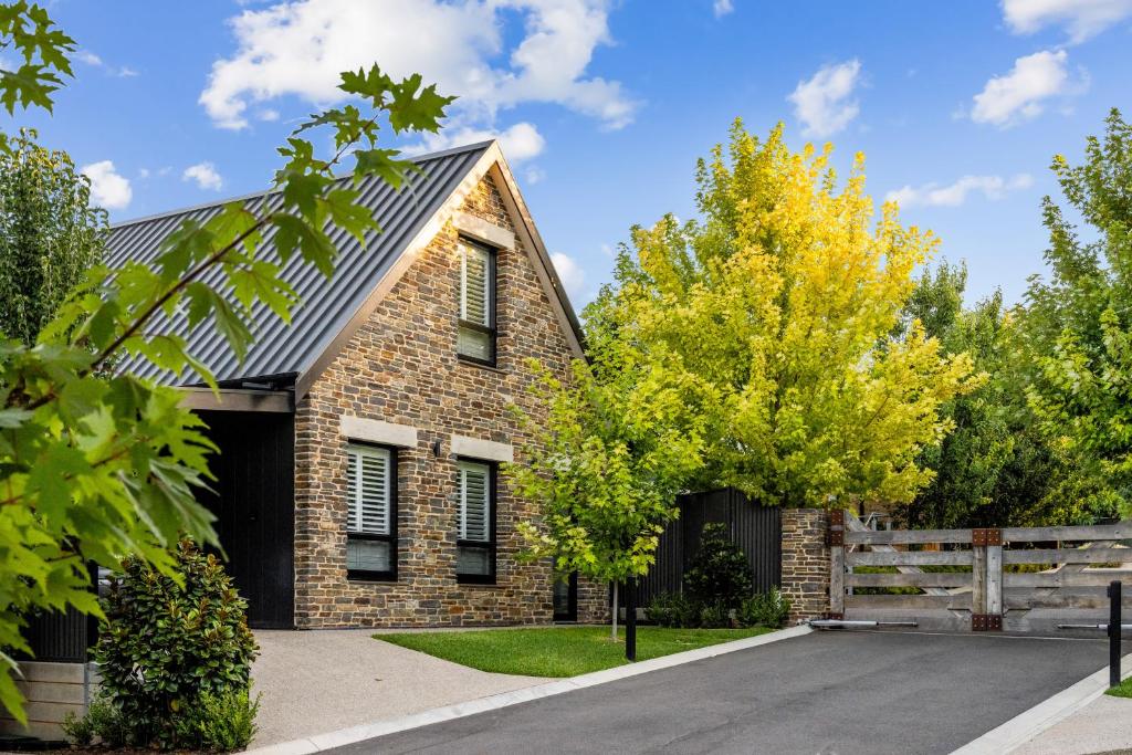 a brick house with a fence and trees at Vale 194 - Newly built in McLaren Vale - 5 holiday homes with king size beds in McLaren Vale