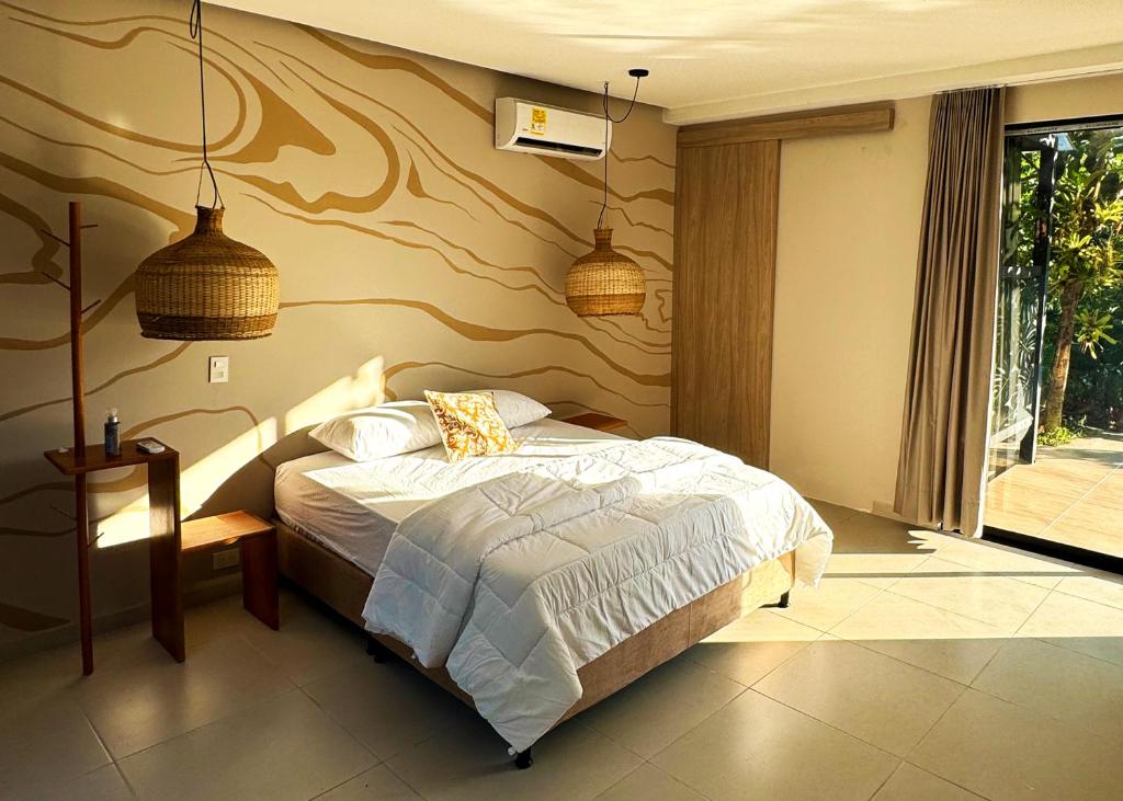 ein Schlafzimmer mit einem Bett und zwei Hängelampen in der Unterkunft Casa Toronja in Montenegro