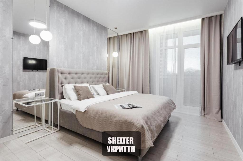 a bedroom with a king sized bed and a television at RainBow Arkadia Apartment in Odesa
