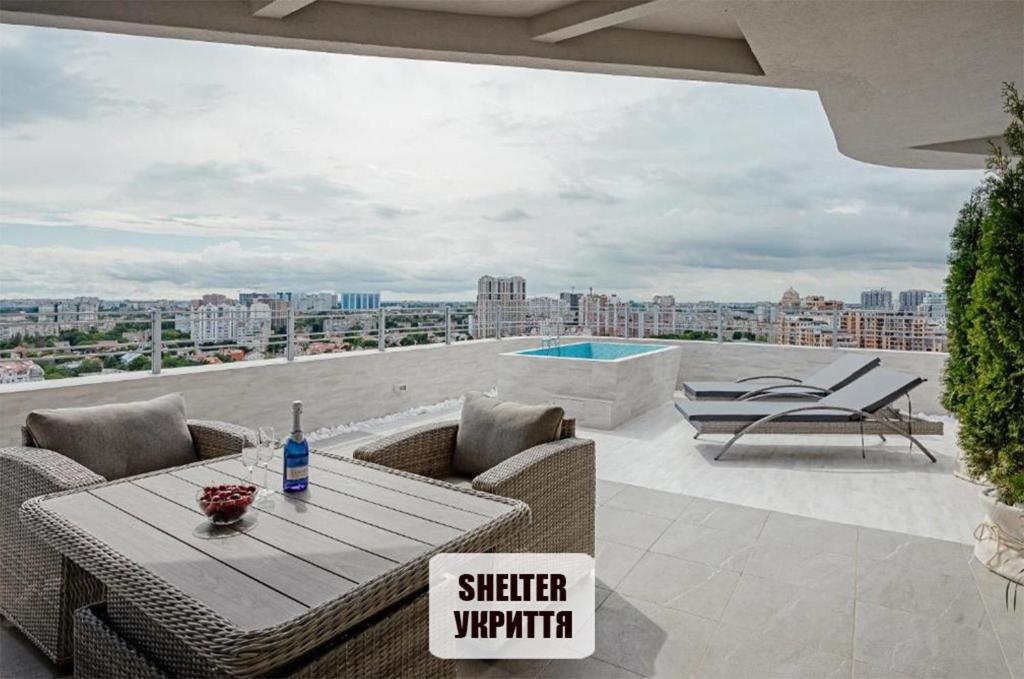 un patio con mesa y sillas en la azotea en Plaza Arcadia Apartments en Odesa