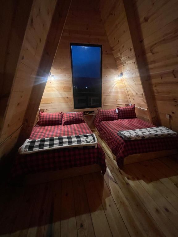 two beds in a room with a flat screen tv at Cabaña El Respiro in El Diamante