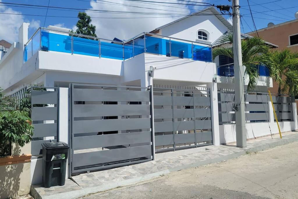 a white house with a gate in front of it at Splendid 3 Bedroom House with Terrace -Near Utesa in Santiago de los Caballeros
