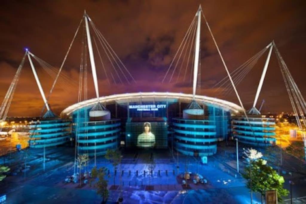 uma representação de um estádio à noite em The Upside down House near Coop Live Arena , Etihad and Mcr City Centre em Manchester