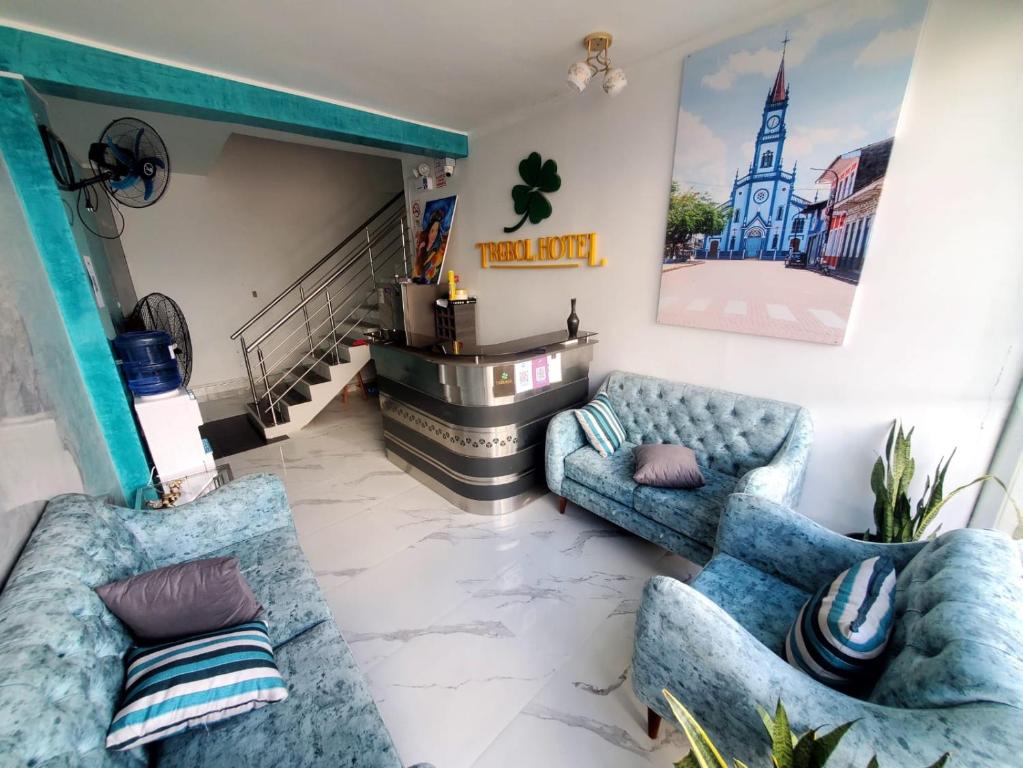 una sala de estar con 2 sofás azules y una escalera en HOTEL EL TREBOL, en Yurimaguas