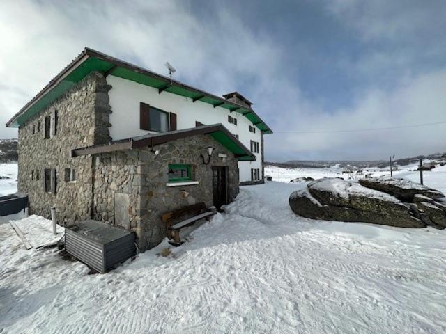 un edificio con nieve en el suelo delante de él en Peer Gynt Ski Lodge, en Perisher Valley