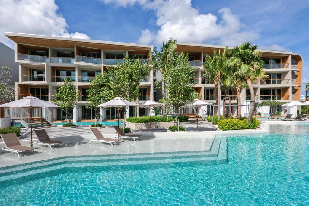 a swimming pool in front of a hotel at Wyndham Grand Nai Harn Beach Phuket in Nai Harn Beach