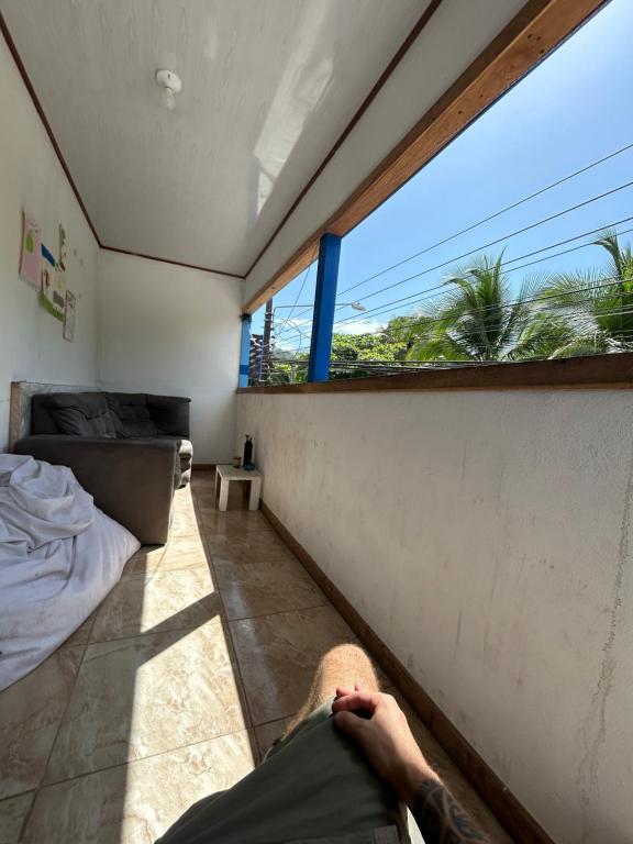 a man laying on the floor in a room with a window at Backpacker Puerto Viejo in Puerto Viejo