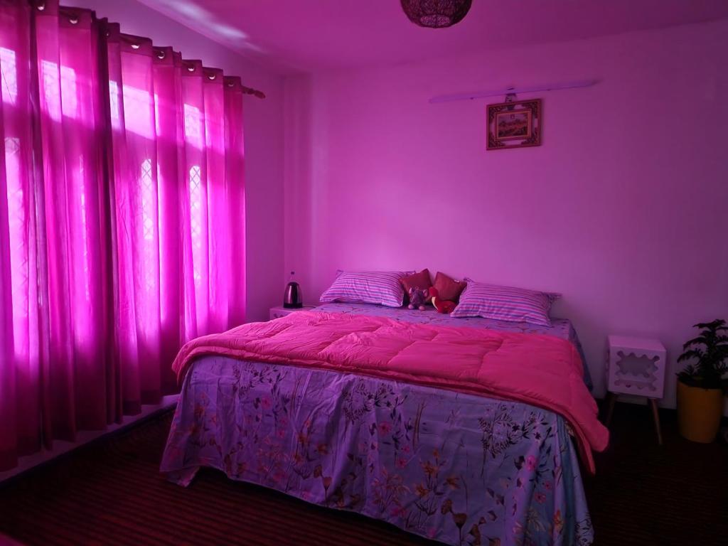 a pink bedroom with a bed with pink lighting at Samarpan in Nainital