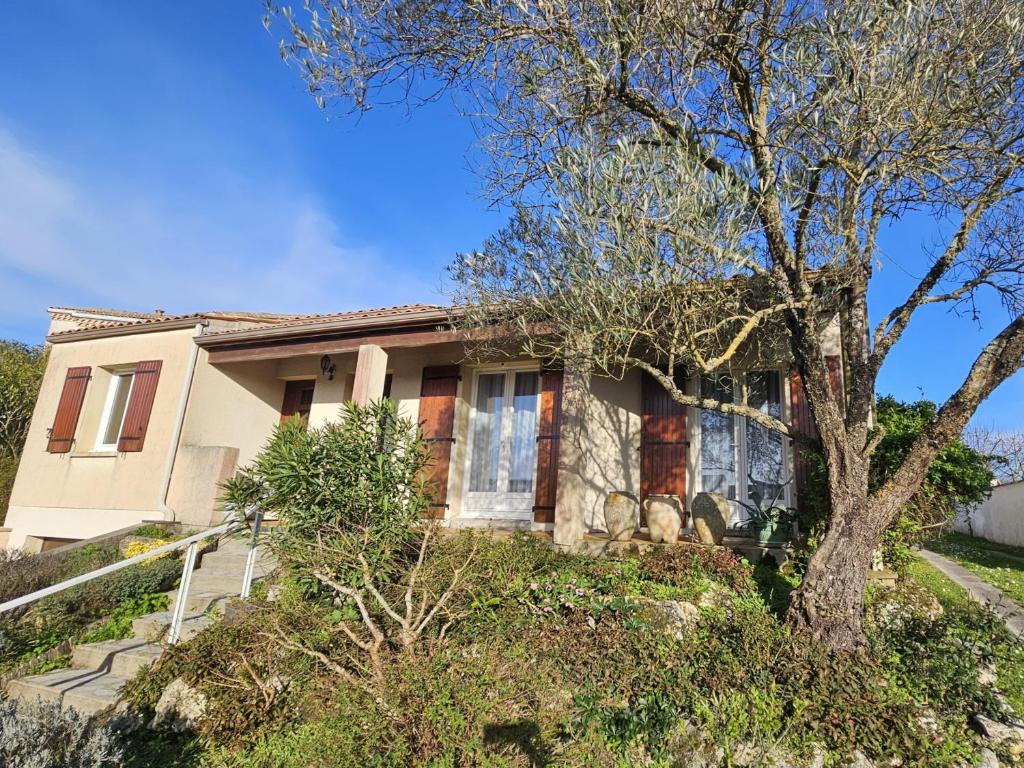 una casa con un árbol delante de ella en Maison Royan, 4 pièces, 8 personnes - FR-1-71-104, en Royan