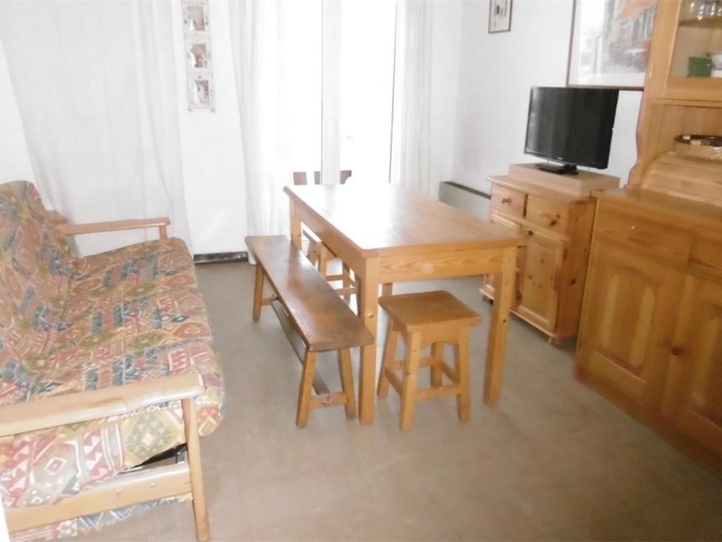 a living room with a wooden table and a couch at Appartement Les Angles, 2 pièces, 4 personnes - FR-1-295-200 in Les Angles