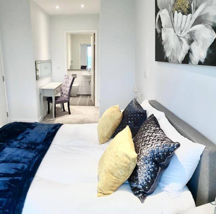 una camera da letto con un letto con cuscini sopra di Luxury Apartment London a Londra