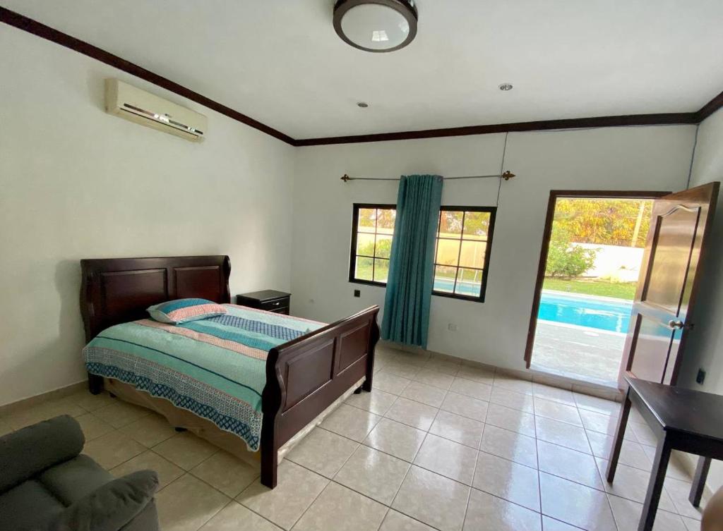 - une chambre avec un lit et une grande fenêtre dans l'établissement MATS, à San Pedro Sula
