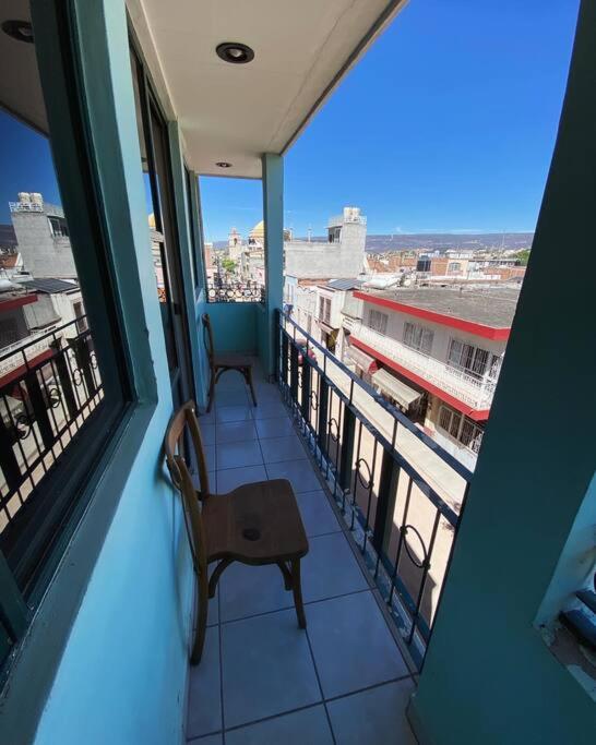 einen Balkon mit einem Stuhl und Stadtblick in der Unterkunft Depa en el centro de Calvillo G in Calvillo