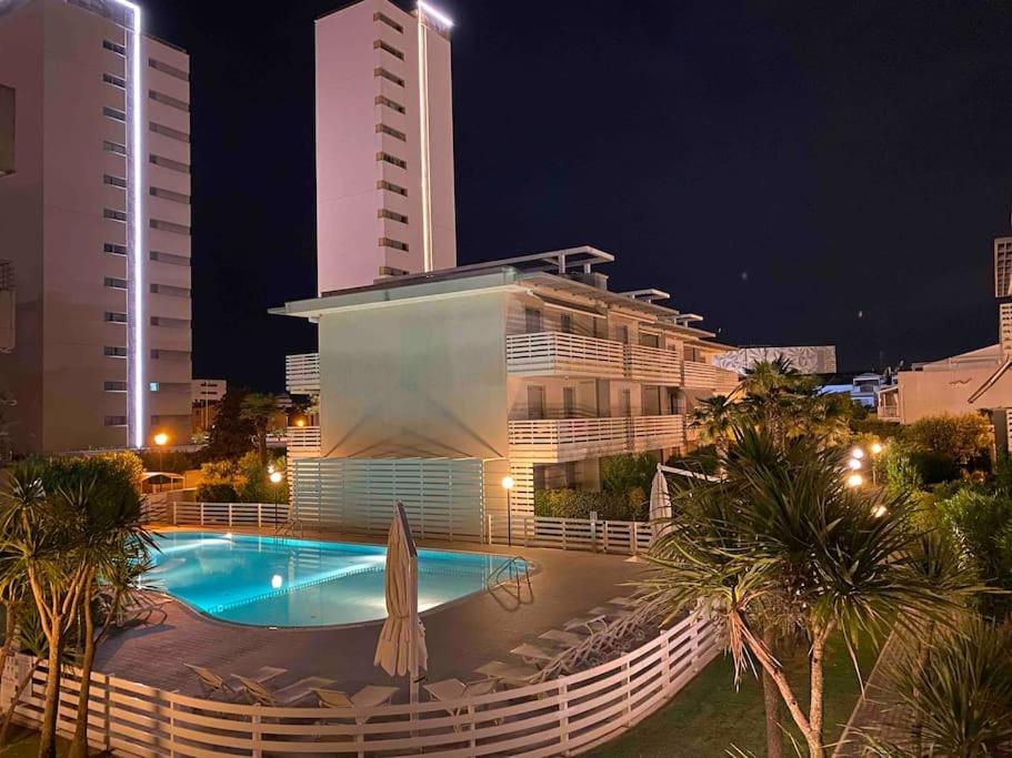 een groot gebouw met een zwembad in de nacht bij Luxury Apartment Centre. Pool. Beach and Shopping in Lido di Jesolo