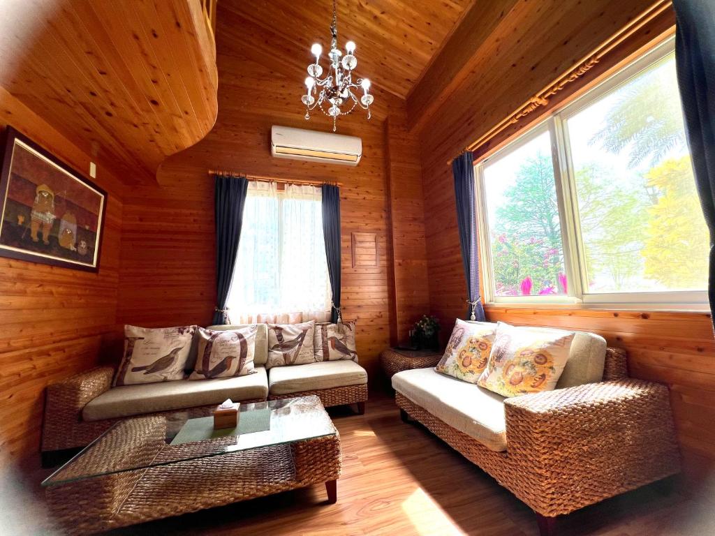 a living room with a couch and chairs in a cabin at Annongriver B&amp;B in Sanxing