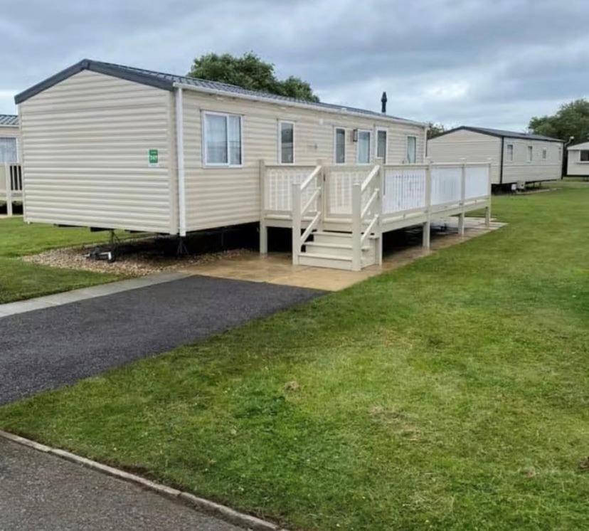 a large white mobile home with a porch at Cosy caravans 10 berth caravan on Butlins Skegness in Skegness