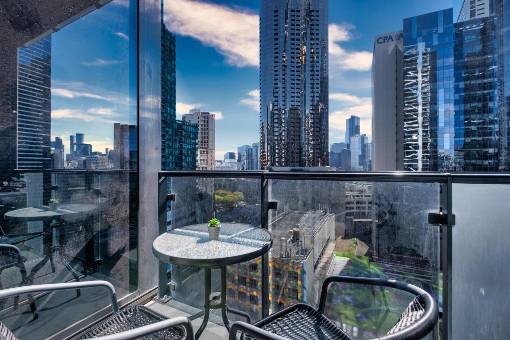 a balcony with a table and chairs and a city skyline at Light Filled 2br Southbank Parking Pool in Melbourne