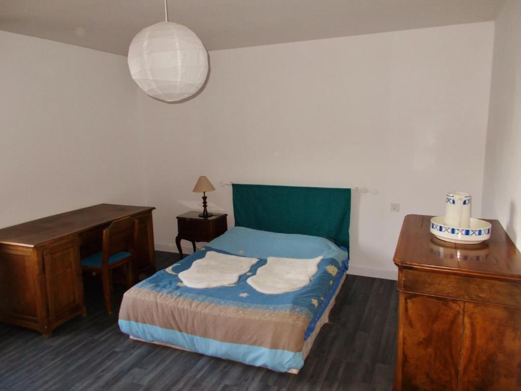 1 dormitorio con cama, escritorio y mesa en Le Gîte des Chevaliers en Sainte-Croix-aux-Mines
