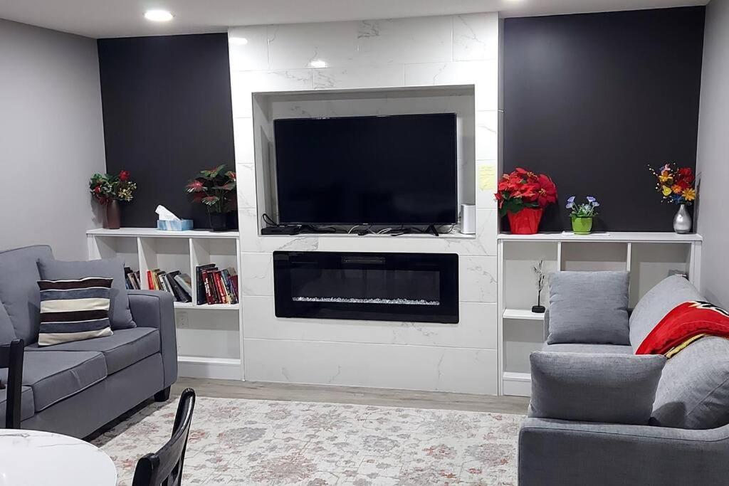 a living room with a flat screen tv on a wall at Cozy 2-Bedroom Basement Guest Suite with Private Entrance and Proximity to the Airport in Edmonton