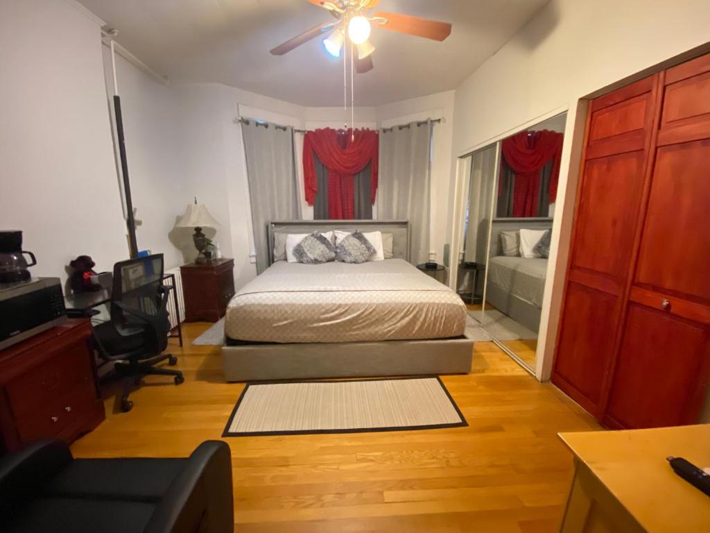 um quarto com uma cama e uma ventoinha de tecto em Harmony place to stay close to all fun in Jersey at 15 minutes to NY City em North Bergen
