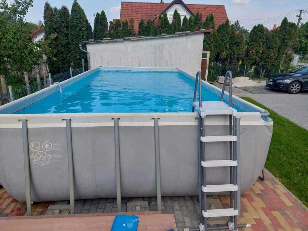 - une grande piscine avec une échelle à côté dans l'établissement schönes Ferienhaus mit grossem Pool 1200 m zum Balaton, à Balatonberény