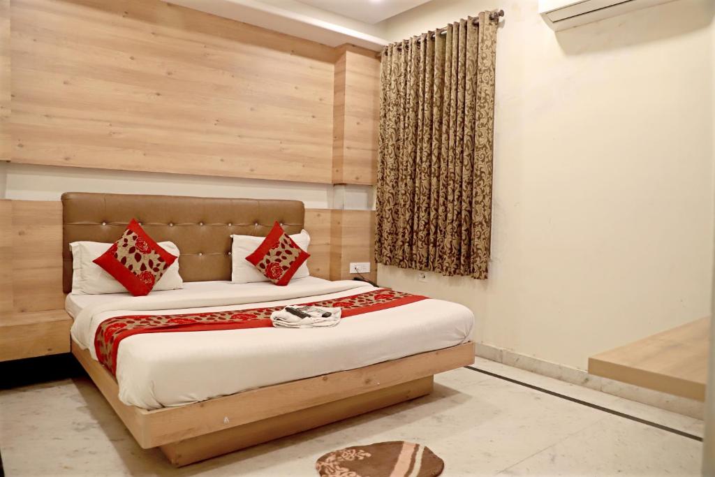 a bedroom with a bed with red pillows at Hotel Klick International in New Delhi