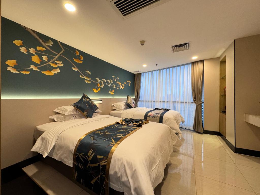 two beds in a hotel room with a painting on the wall at Yixuan Yasi Apartment-free shuttle during the Canton Fari in Guangzhou
