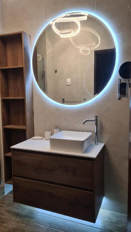 a bathroom with a sink and a large mirror at Jardines de Milé in Laredo Hacienda