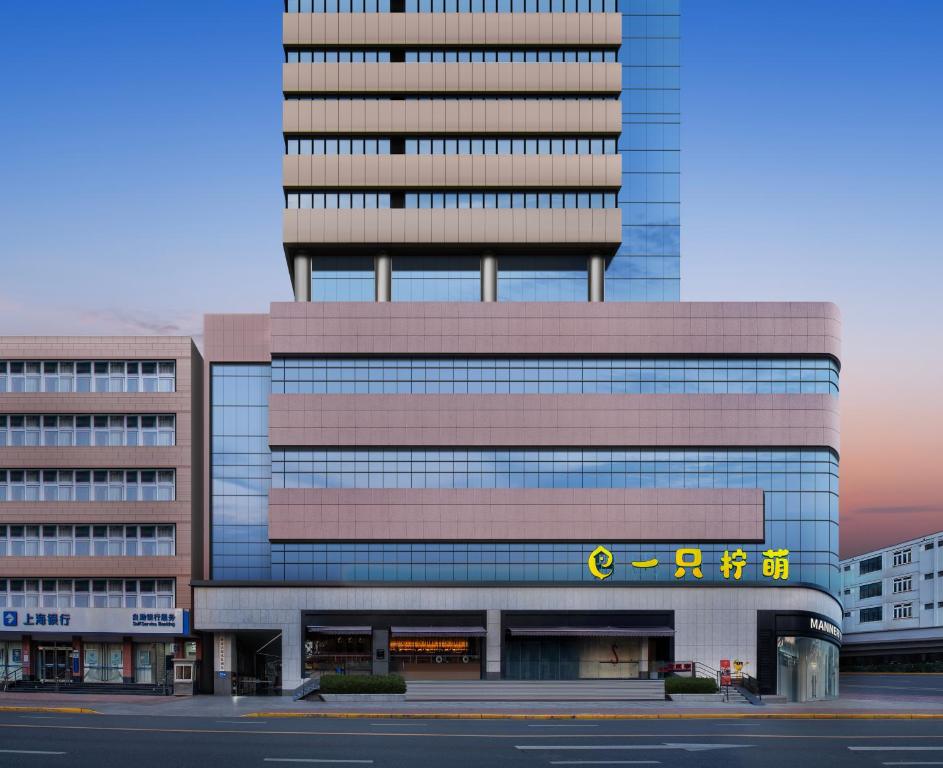 ein hohes Gebäude mit einem Schild davor in der Unterkunft Lemon Hotel - Metro Line 1 Line 7 Changshu Road 200 meters in Shanghai