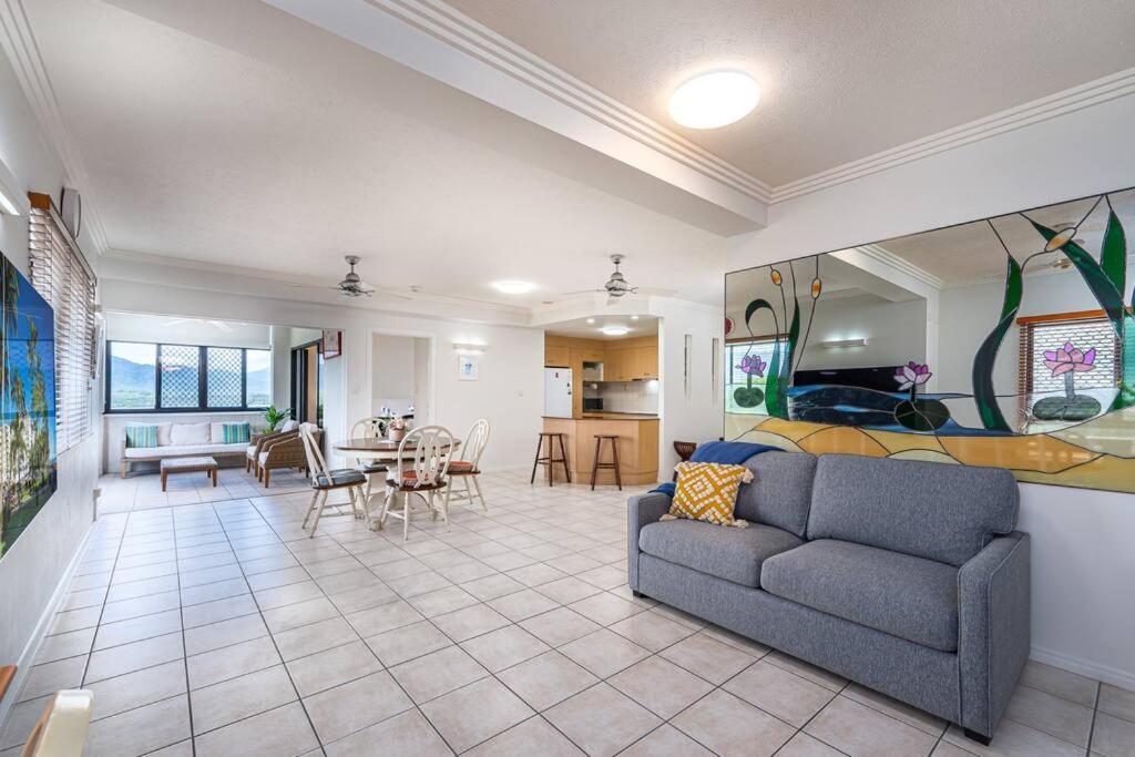 ein Wohnzimmer mit einem Sofa und einem Esszimmer in der Unterkunft An Adorable Apartment on Abbott - Stunning Views in Cairns