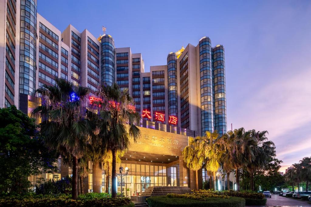 un gran edificio con palmeras delante en Newyantai Hotel Hainan, en Haikou