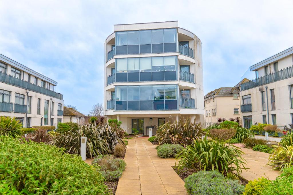 an apartment building with glass windows and plants at The Regency Suite - Modern 2-Bed 1-Bath Apartment in Chertsey