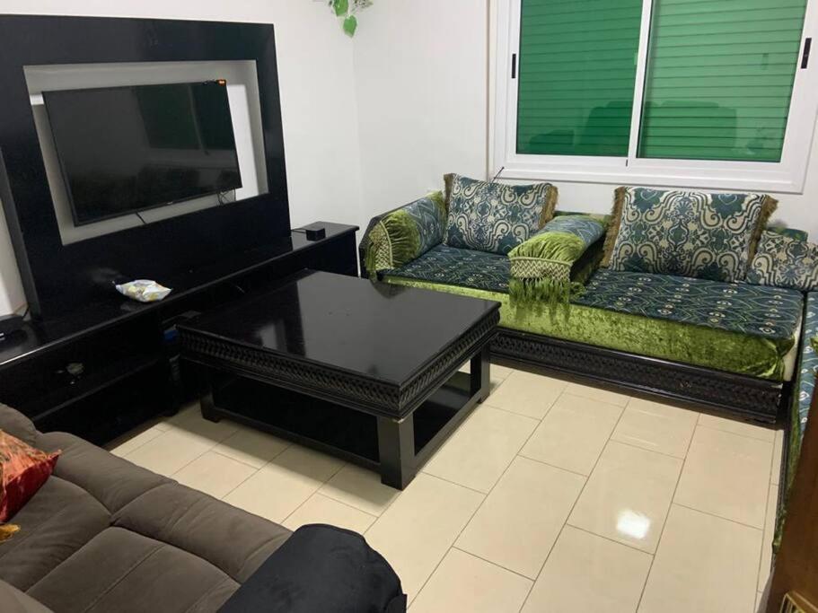 a living room with two couches and a flat screen tv at Convenient Spacious apartment in Amman