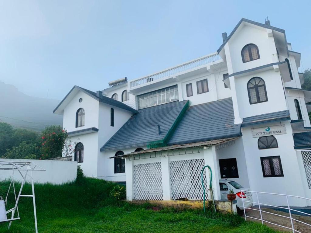a large white building with a gate in front of it at BOB Lesiure in Ooty