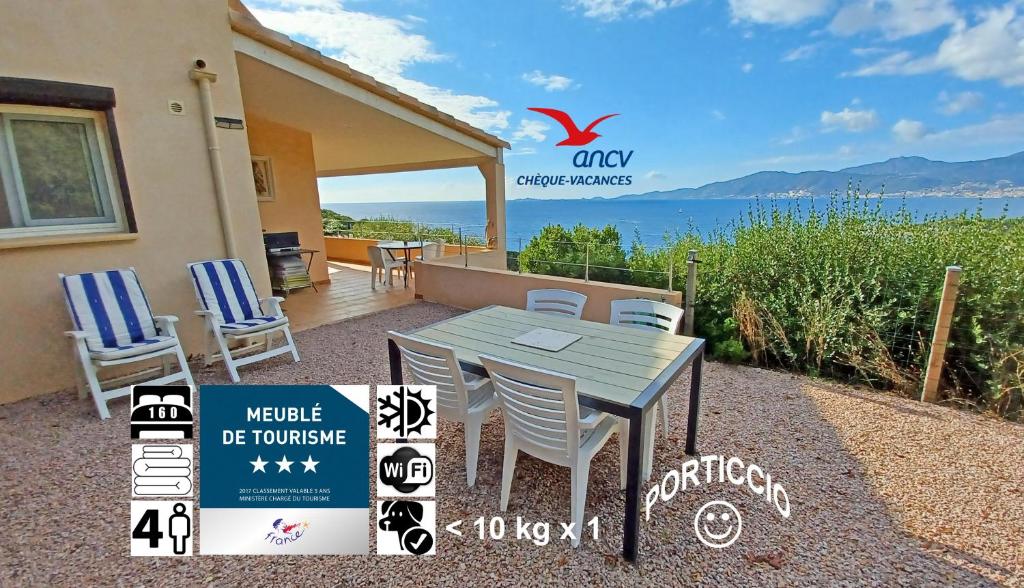 una mesa y sillas en el patio de una casa en Soleil Topaze - 68 m2 - Terrasse - Jardinet - Transats - Vue mer panoramique sur toute la baie, en Porticcio