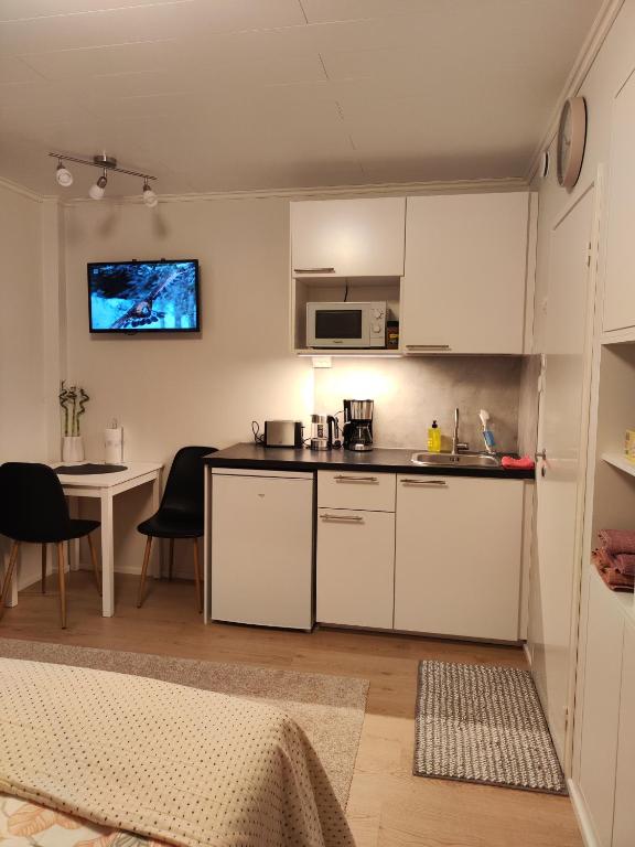 a kitchen with white cabinets and a table with chairs at Kauppakatu 57 - 8 in Varkaus