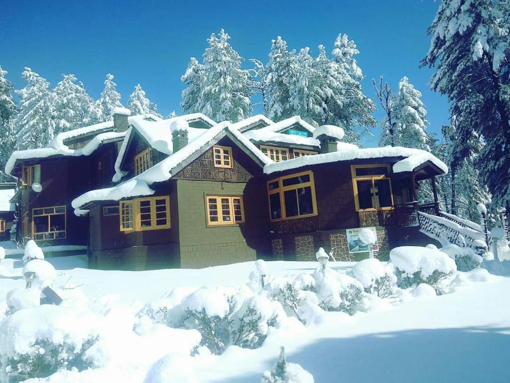 una casa está cubierta de nieve con árboles en Heritage Aksa, en Pahalgām