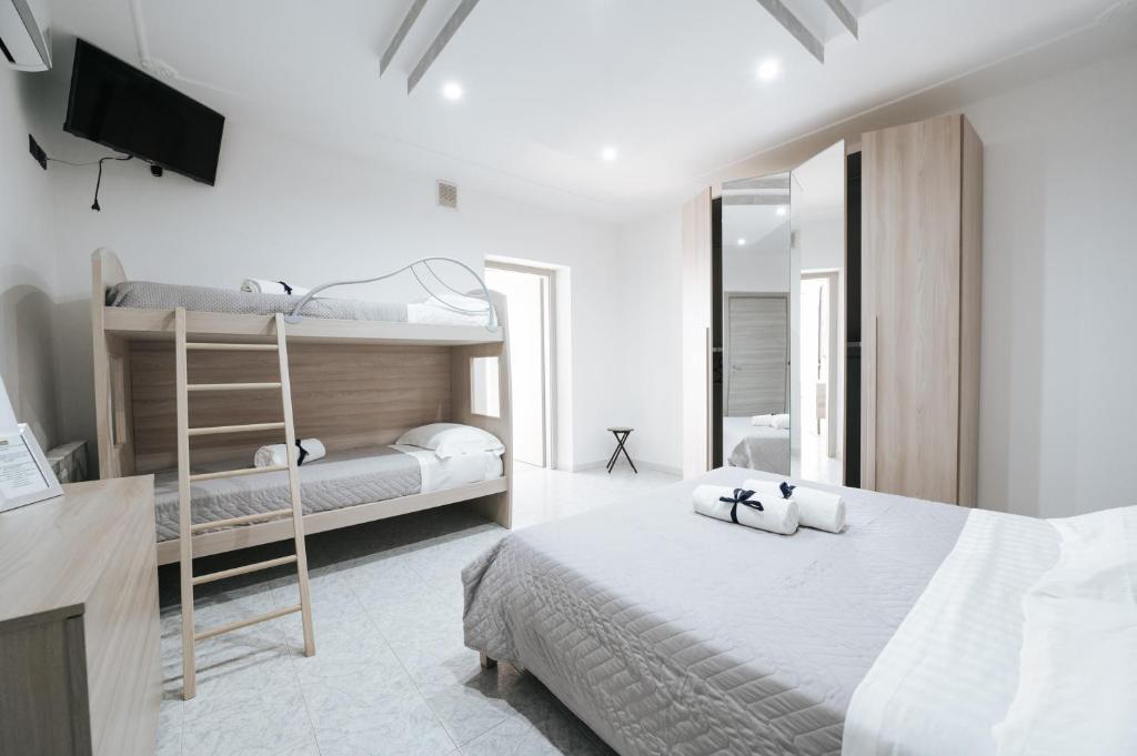 a bedroom with two bunk beds and a television at Gioema in Borgo Vodice