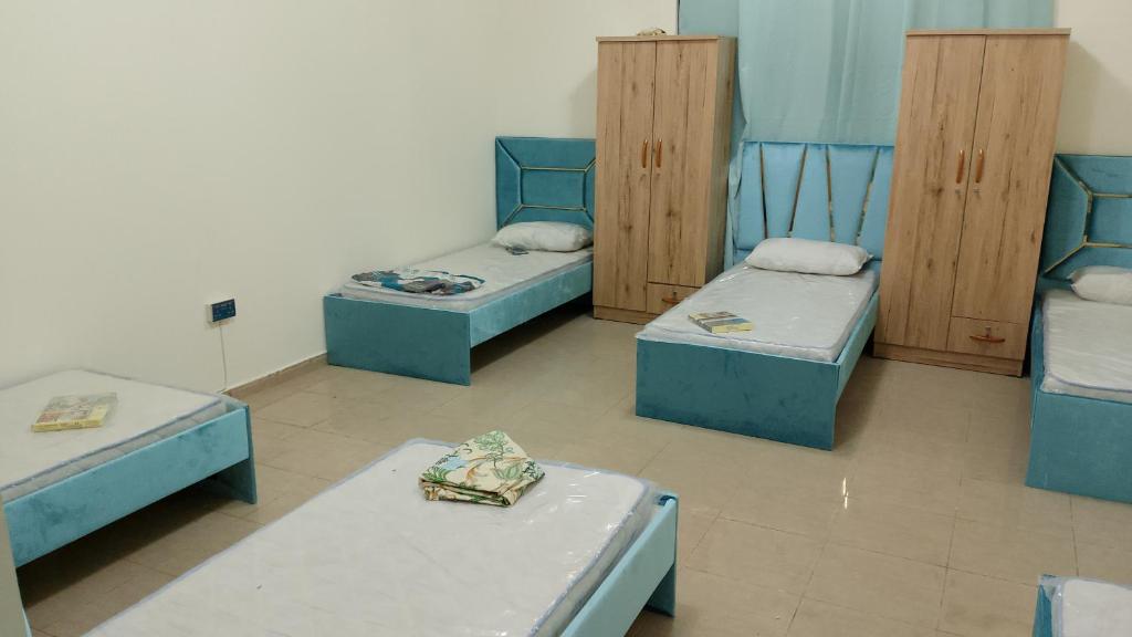 um quarto com quatro camas num quarto em Cornich ajman em Ajman