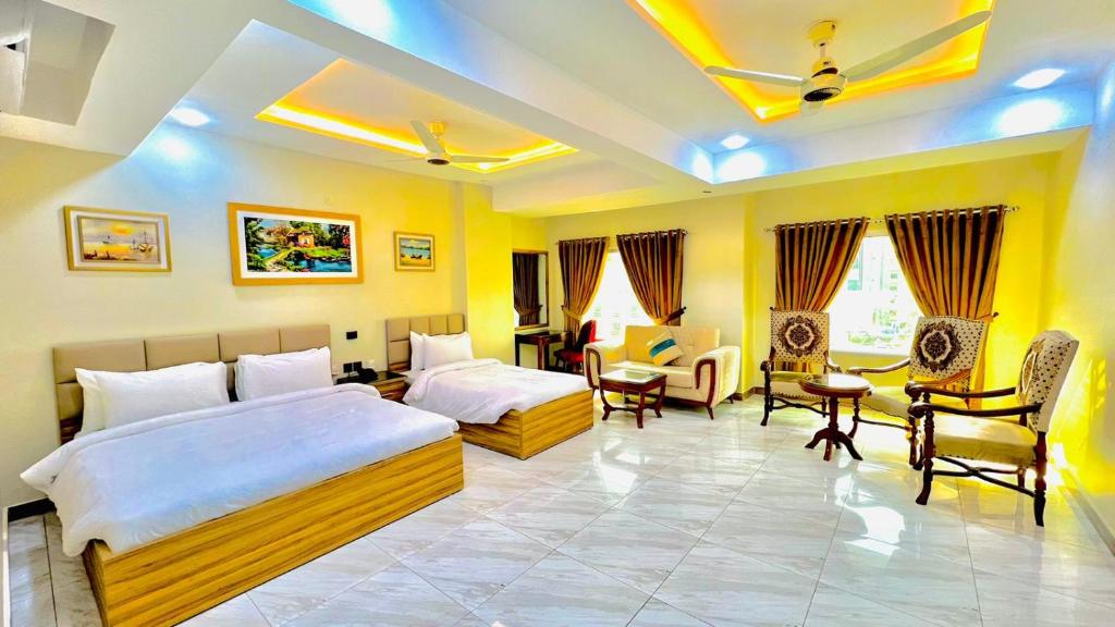Pearl Inn Hotel في كراتشي: غرفة نوم بسريرين وطاولة وكراسي