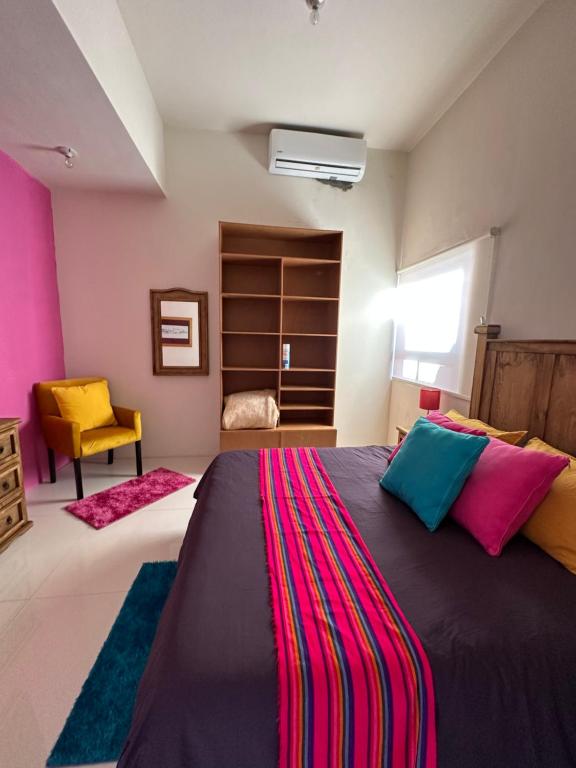 a bedroom with a large bed with colorful pillows at Recámara con terraza y Firepit privados in Santiago
