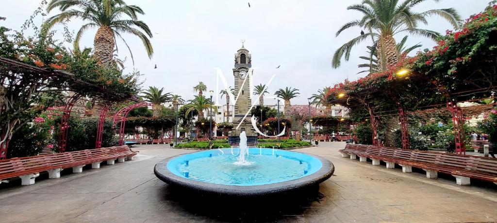 a fountain in a courtyard with a clock tower at MC Suite - Centro in Antofagasta