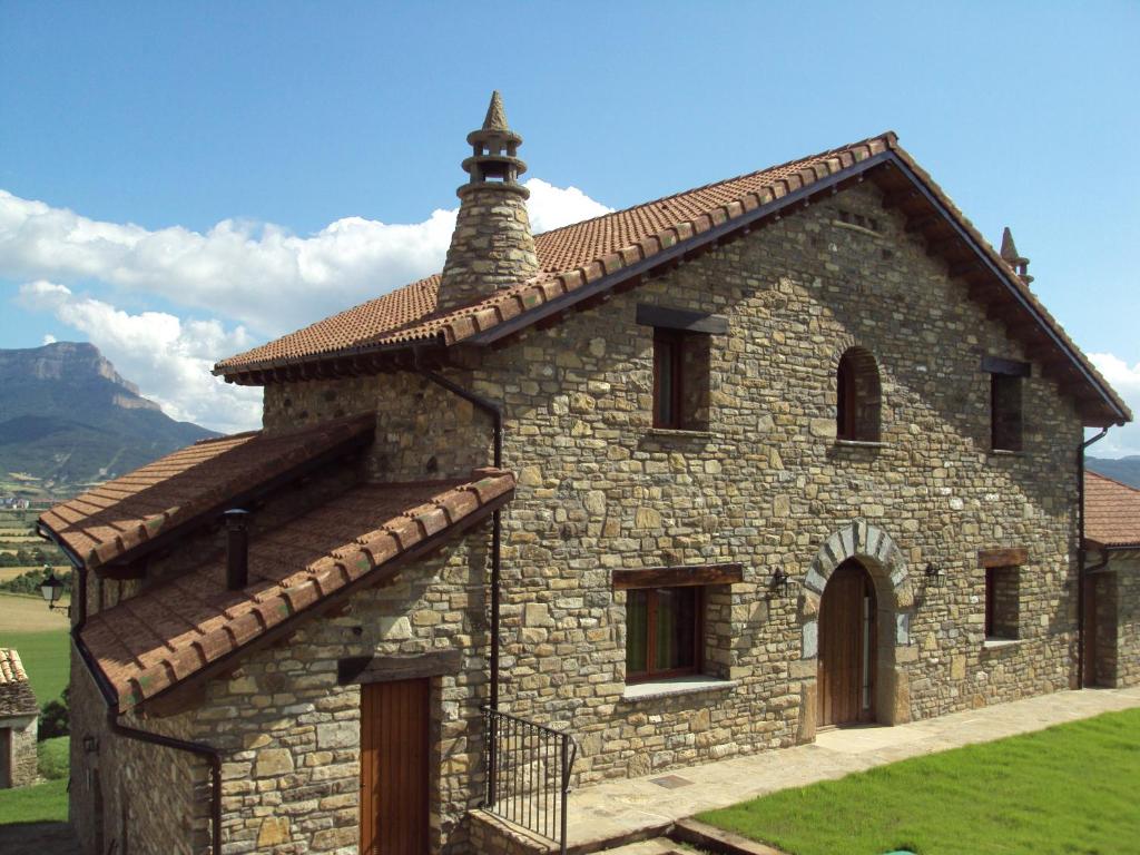 ein kleines Steingebäude mit einem Kamin darüber in der Unterkunft Casa Rural O Fraginal in Guasillo