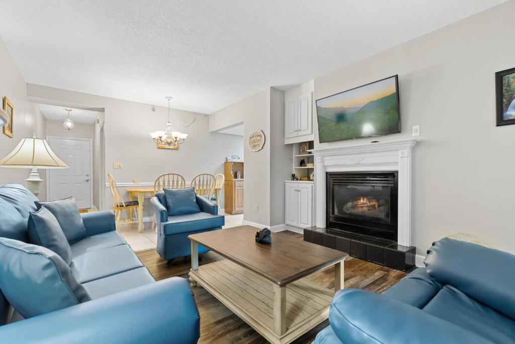 sala de estar con muebles azules y chimenea en River View w Pool. Close to Many Attractions, en Pigeon Forge