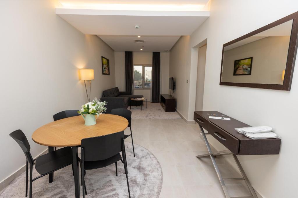 - un salon avec une table et des chaises dans l'établissement Saray Hotel Apartments, à Koweït