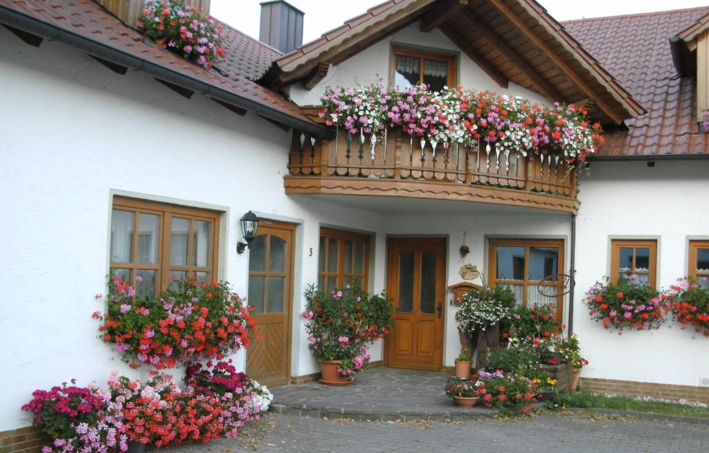 a white house with flowers on the balcony at Bauernhof Nißl in Neunburg vorm Wald