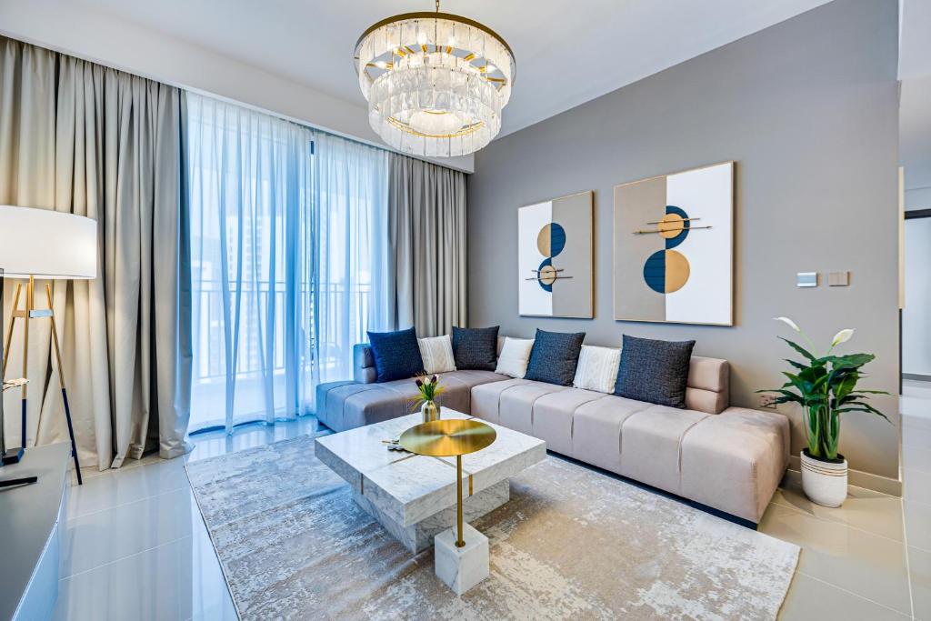 a living room with a couch and a table at Pleasant new apartment in Dubai Creek Harbour in Dubai