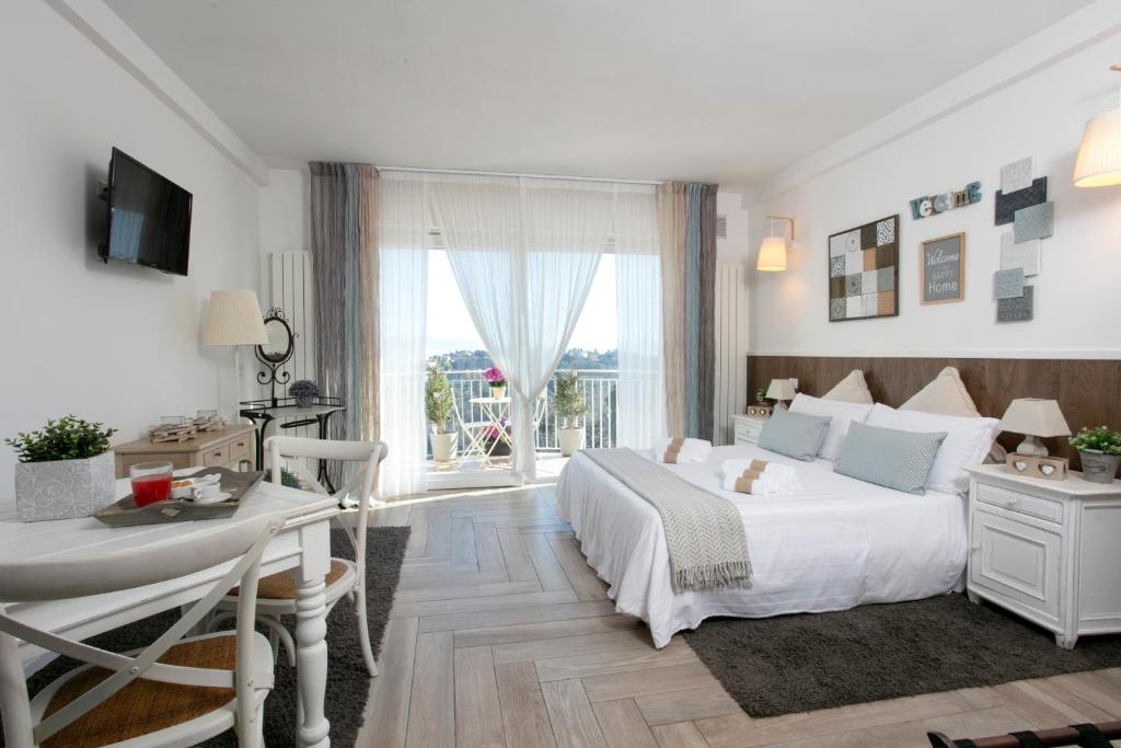 Residenza il Punto في بيروجيا: غرفة نوم بيضاء بها سرير ومكتب ونافذة